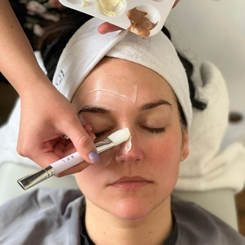 A mask being brushed on under the eye