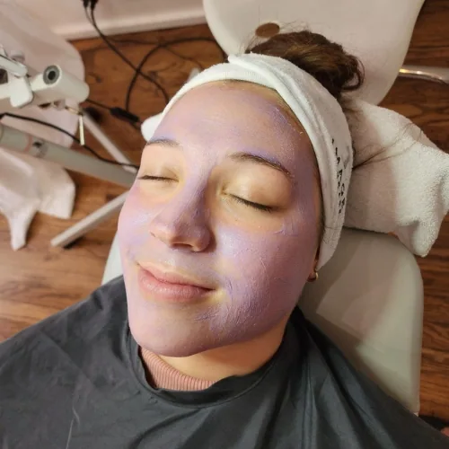A client lying back with a lavender treatment layer on her face