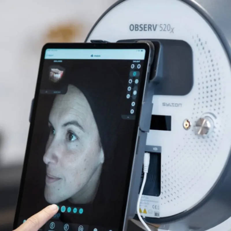 An Observ skin analysis machine beside a tablet showing a scanned face